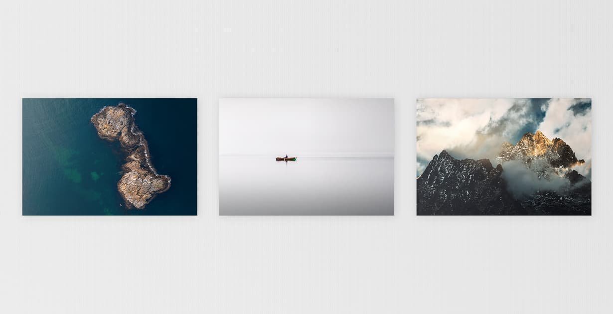 Three nature photographs showing a drone image of an island, a fisherman on a lake, and a mountain on a white wall