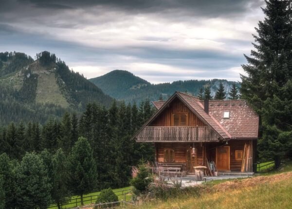 A small wooden house in nature facing a mountain