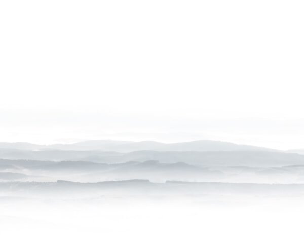 A minimalist landscape photo of some foggy hills