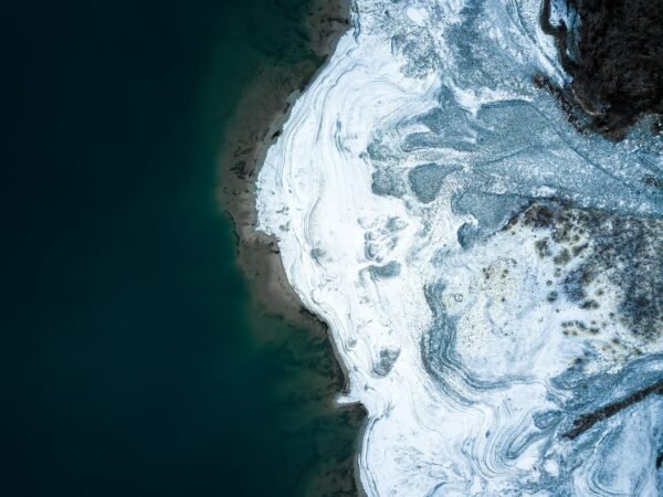 An aerial photograph of a glacier melting into a lake