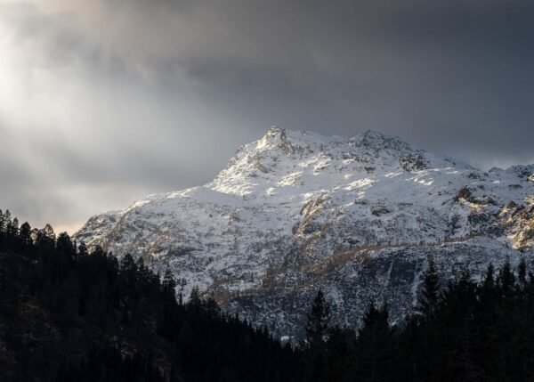 Nature photograph of a snowy mountain as the sun hits its peak