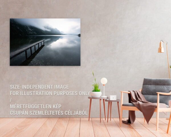 A photography print of a dock on the shore of a lake hanging in a cozy home