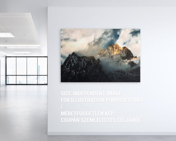 Egy irodában lógó motivációs fali kép, melyen egy napsütötte felhős hegycsúcs látható