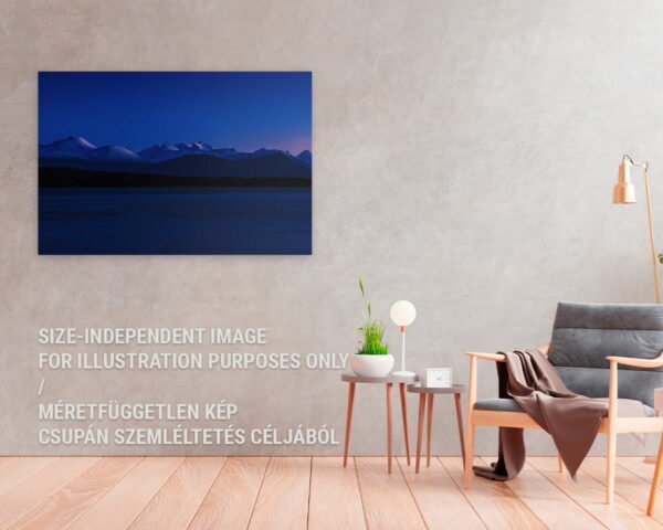 A fine art print of a mountain with purple peaks hanging at a home