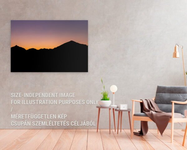 A fine art print hanging at a home featuring a silhouette of a mountain and the colors of a sunset