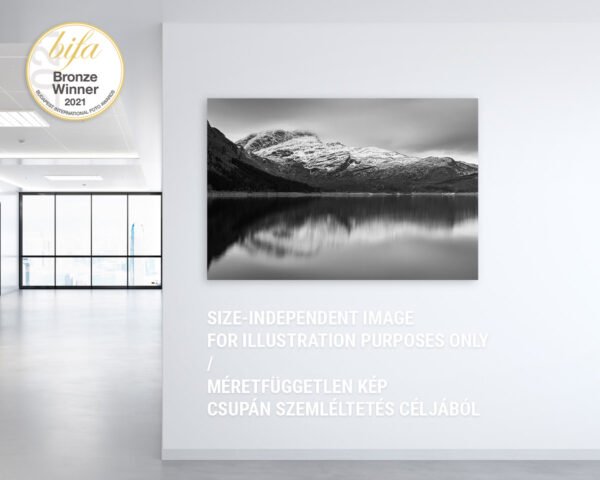 An awarded photograph of a cloudy mountain hanging on an office wall