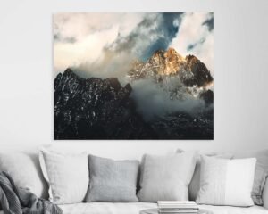 Sunny cloudy mountaintop photograph hanging on a home's wall