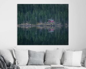 Photograph of a red house in a green forest hanging in a living room