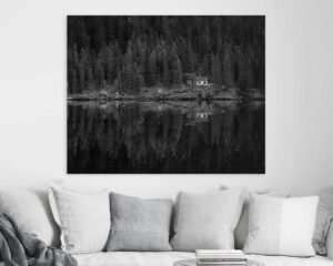 Kanapé felett lóg egy fekete fehér fénykép egy házról, valamint egy erdőről